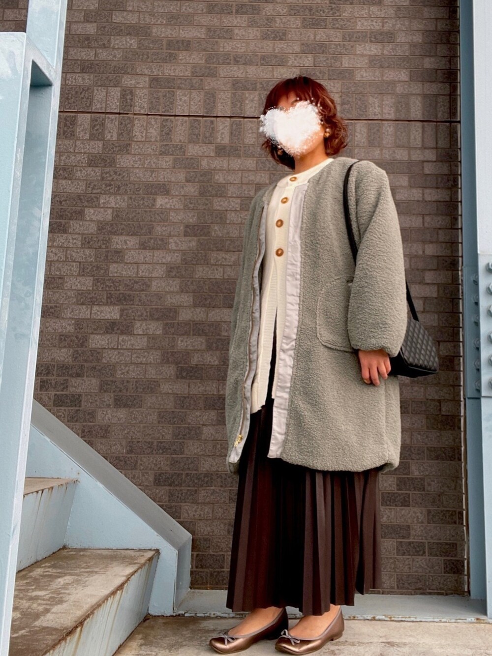 グリーン系のその他アウター、ホワイト系のニット/セーター、ゴールド系のバレエシューズを着用したレディースの冬コーディネートの1枚目の写真