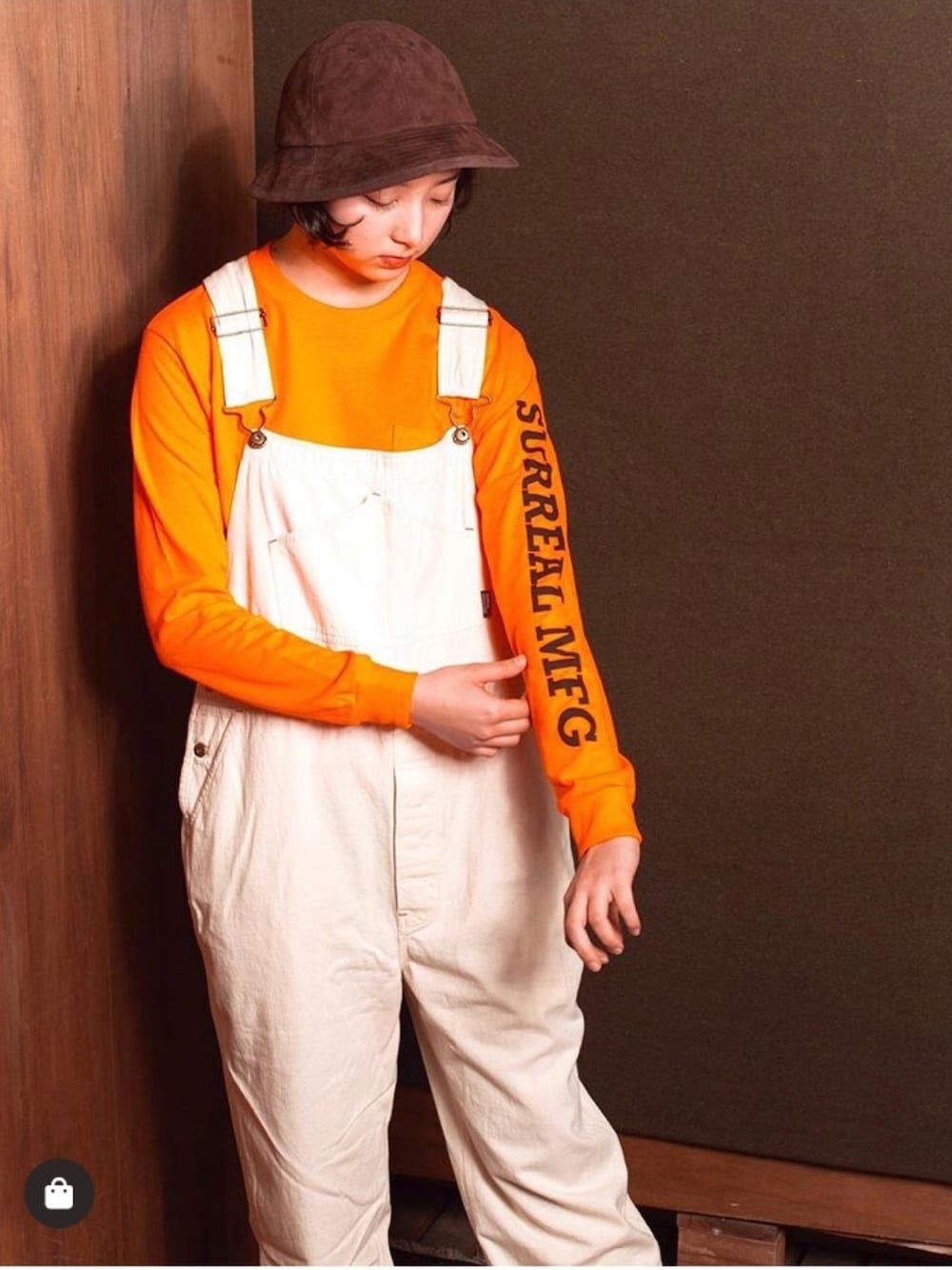 ホワイト系のオールインワン・サロペット、オレンジ系のTシャツ/カットソー、ブラウン系のハットを着用したメンズの春コーディネートの1枚目の写真