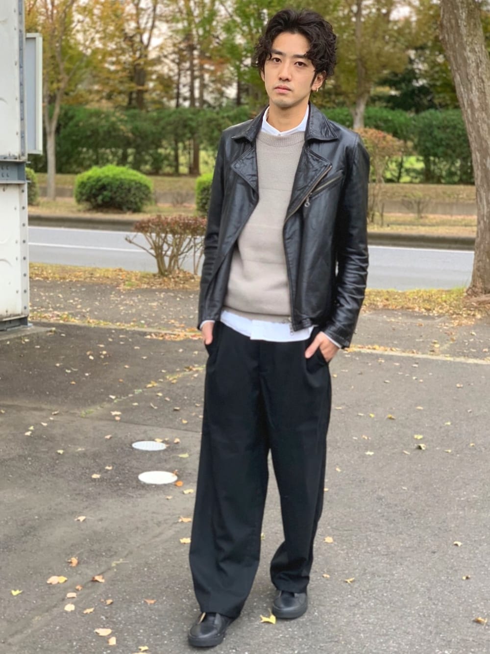 ブラック系のライダースジャケット、ベージュ系のニット/セーター、ホワイト系のシャツ/ブラウスを着用したメンズの秋コーディネートの1枚目の写真