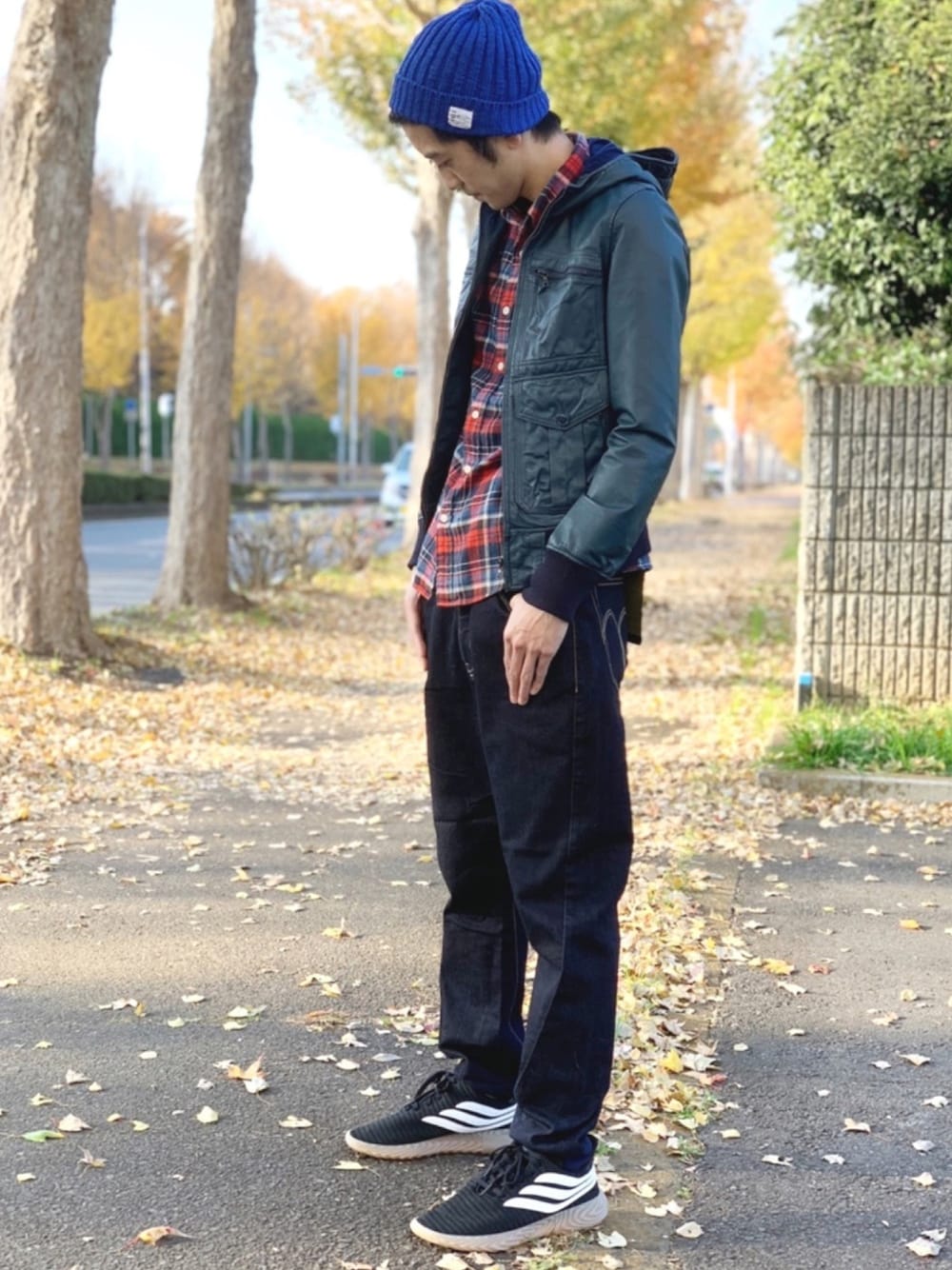 ブルー系のブルゾン、ブルー系のデニムパンツ、ブラック系のスニーカーを着用したメンズの冬コーディネートの1枚目の写真