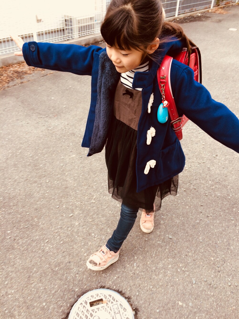 ブラック系のワンピース/ドレス、ブルー系のデニムパンツ、ピンク系のスニーカーを着用したキッズの春コーディネートの1枚目の写真