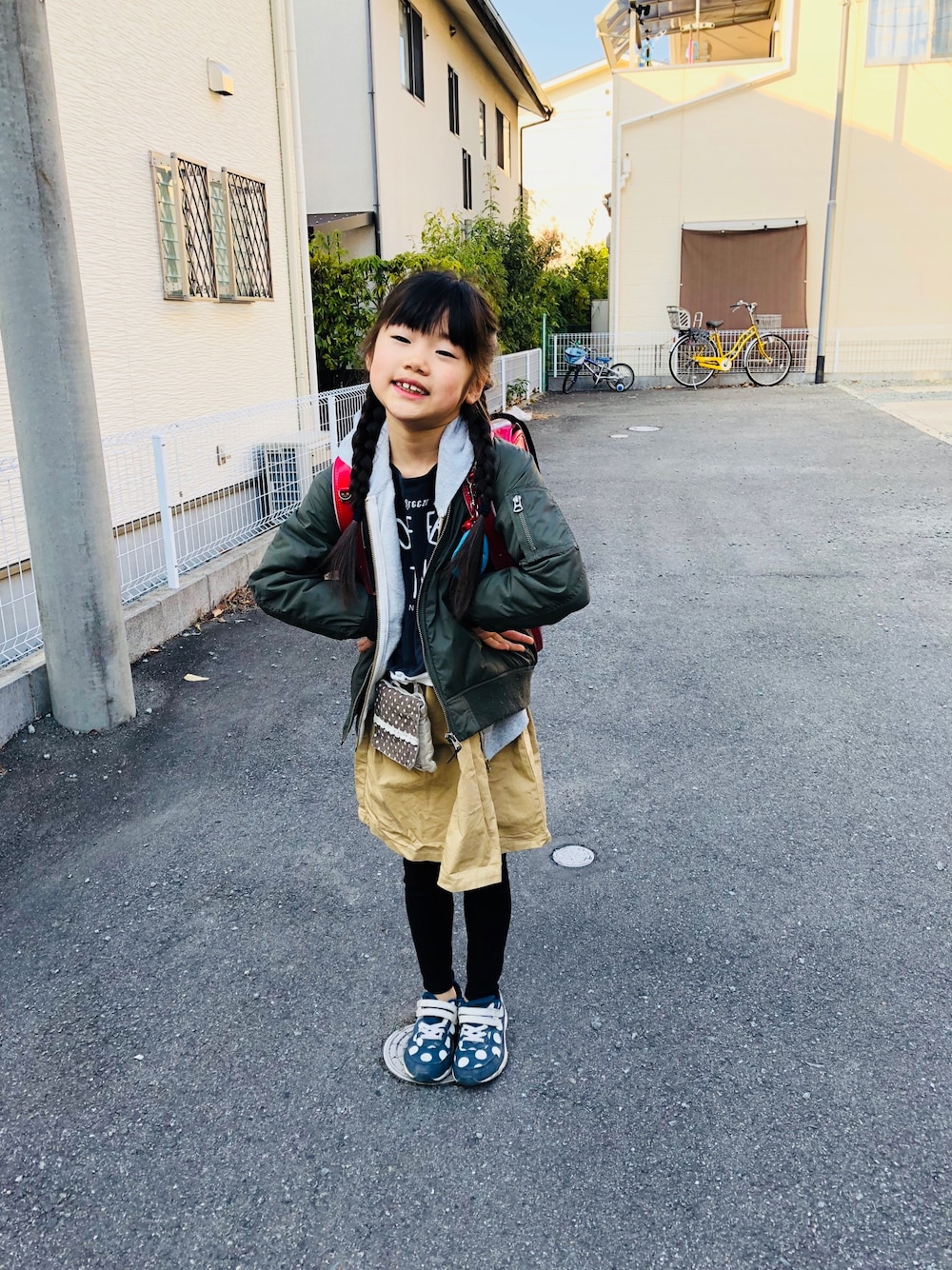 グレー系のワンピース、ブルー系のスニーカー、グレー系のパーカーを着用したキッズの春コーディネートの1枚目の写真