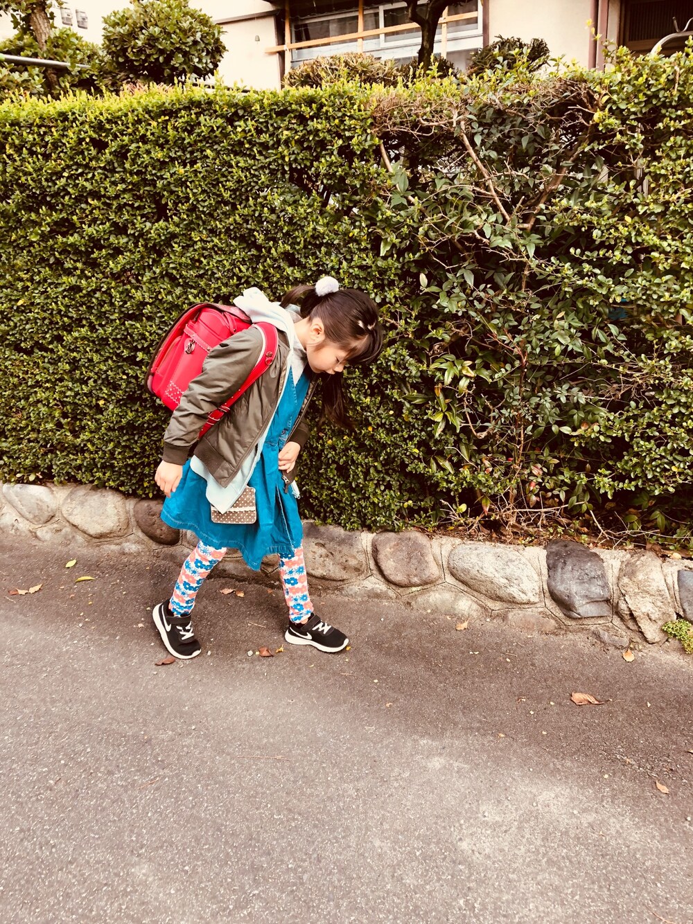 ブルー系のジャンパースカート、ブラック系のスニーカー、グレー系のTシャツ/カットソーを着用したキッズの春コーディネートの1枚目の写真