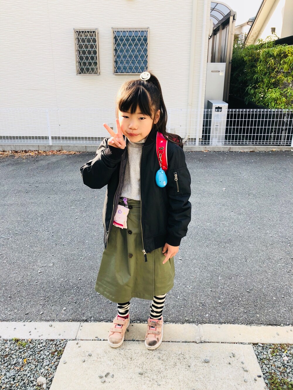 グレー系のTシャツ/カットソー、ピンク系のスニーカー、グリーン系のスカートを着用したキッズの春コーディネートの1枚目の写真