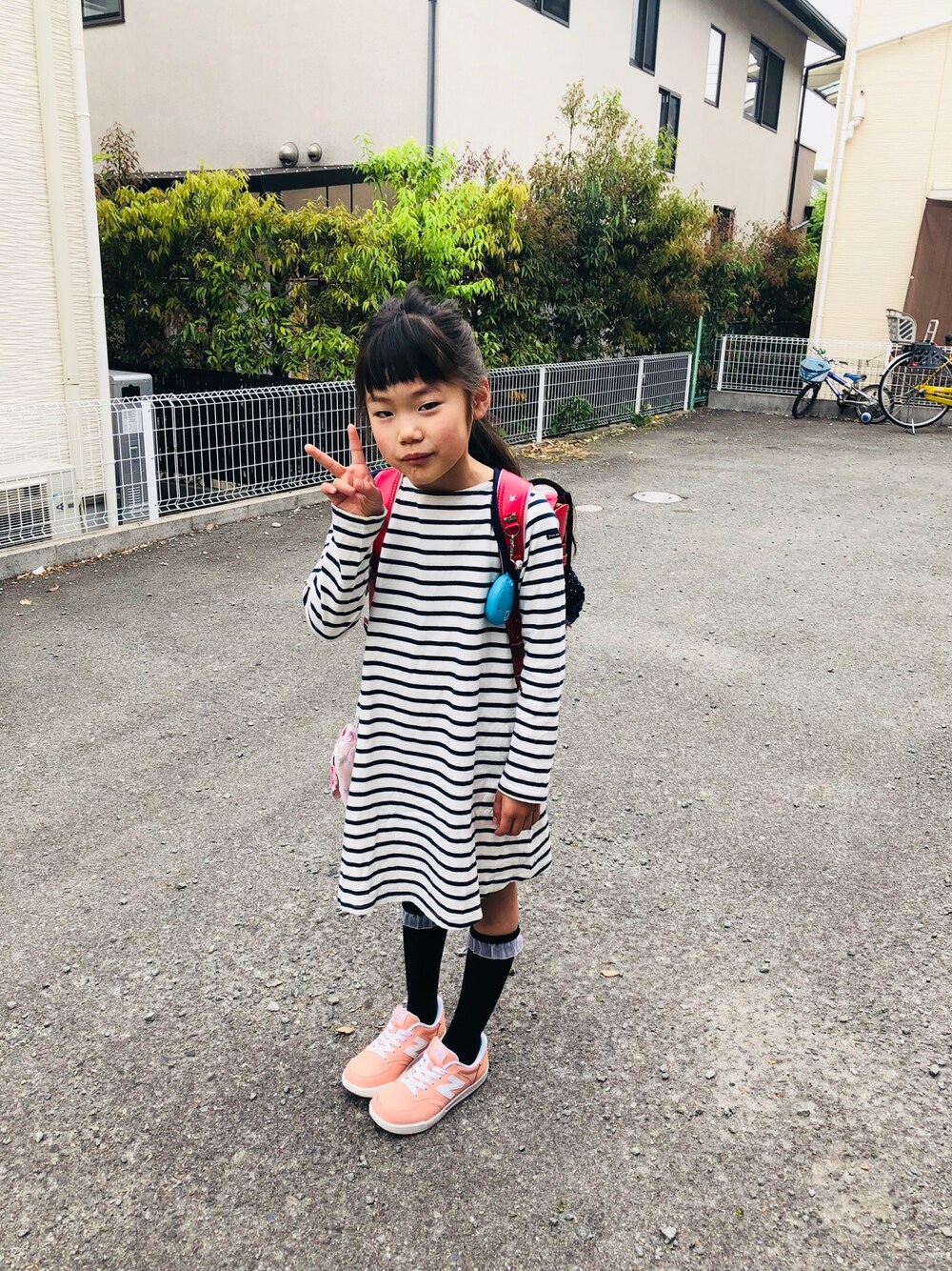 ブルー系のワンピース、ピンク系のスニーカー、ブラック系のソックス/靴下を着用したキッズの春コーディネートの1枚目の写真