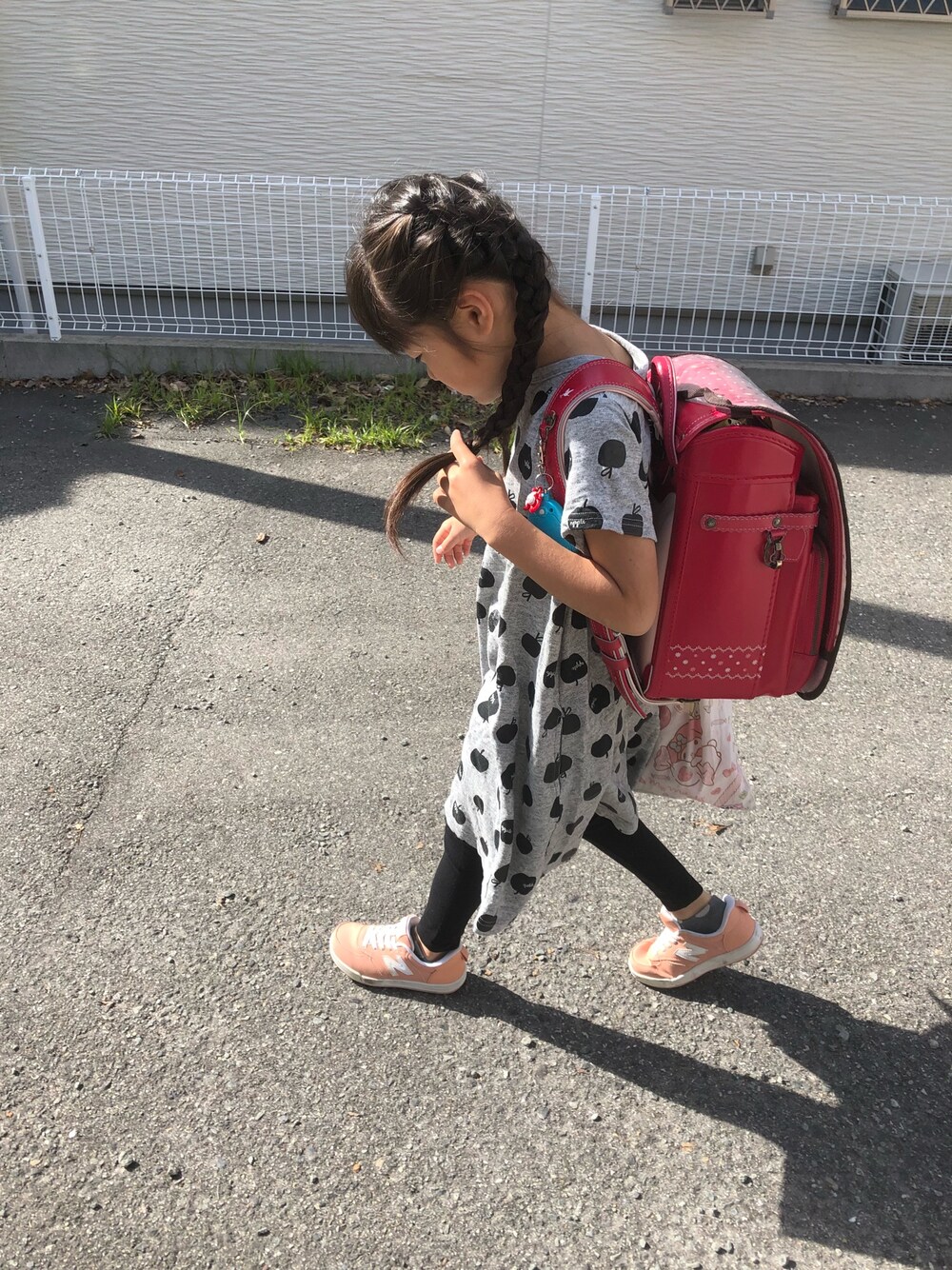 ピンク系のスニーカー、グレー系のワンピース、ブラック系のレギンス/スパッツを着用したキッズの春コーディネートの1枚目の写真