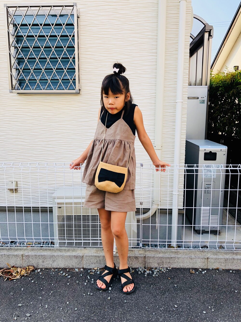 ブラック系のTシャツ/カットソー、ブラウン系のオールインワン・サロペット、ブラック系のショルダーバッグを着用したキッズの夏コーディネートの1枚目の写真