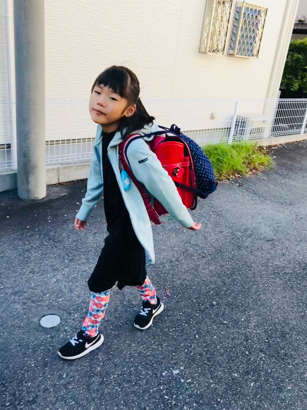 ブラック系のスニーカー、ブラック系のワンピース、グレー系のパーカーを着用したキッズの秋コーディネートの1枚目の写真