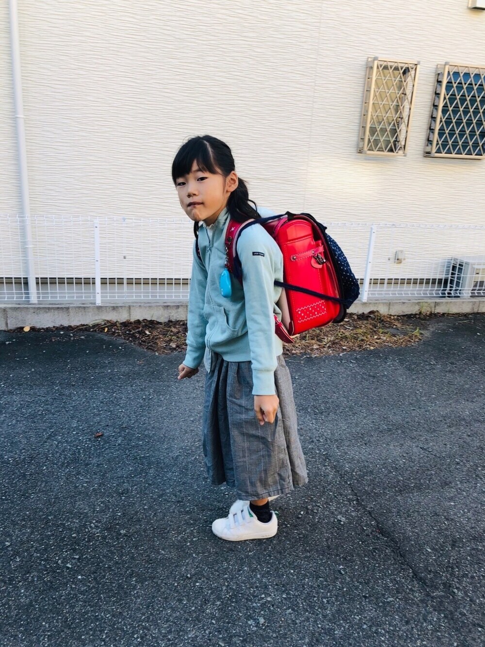 ホワイト系のスニーカー、グレー系のパーカー、ブラック系のその他パンツを着用したキッズの秋コーディネートの1枚目の写真