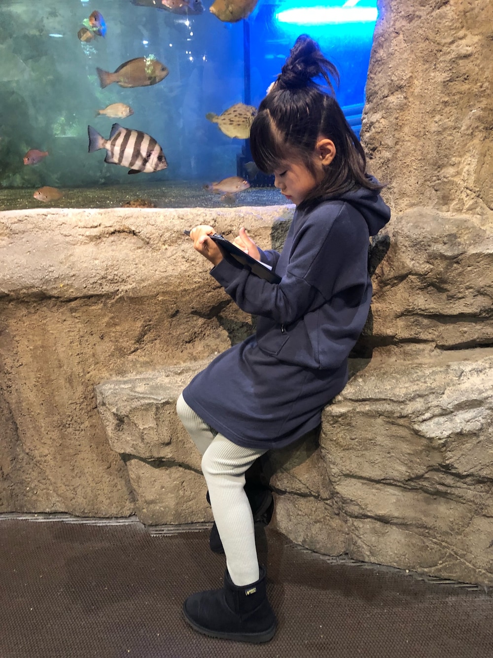 ブラック系のブーツ、ブルー系のワンピース、グレー系のムートンコートを着用したキッズの冬コーディネートの1枚目の写真