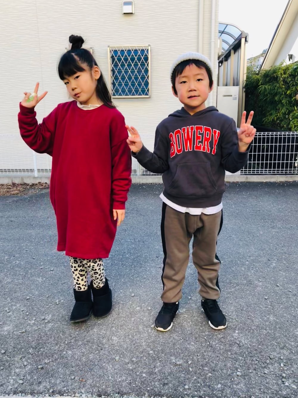 レッド系のワンピース、グレー系のパーカー、グリーン系のその他パンツを着用したキッズの冬コーディネートの1枚目の写真