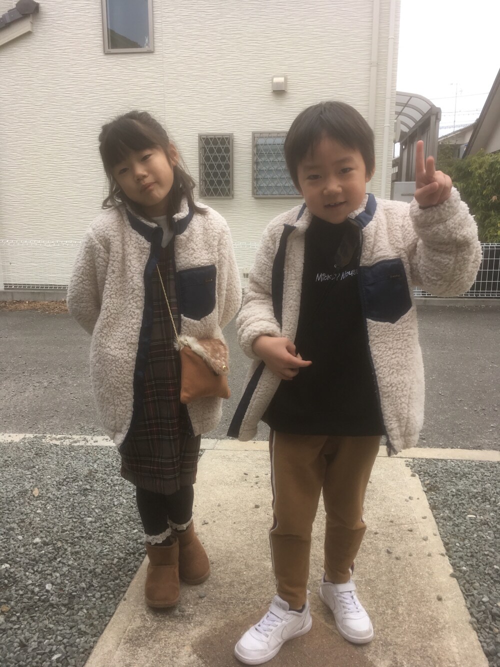 ホワイト系のブルゾン、グレー系のワンピース/ドレス、ホワイト系のTシャツ/カットソーを着用したキッズの冬コーディネートの1枚目の写真