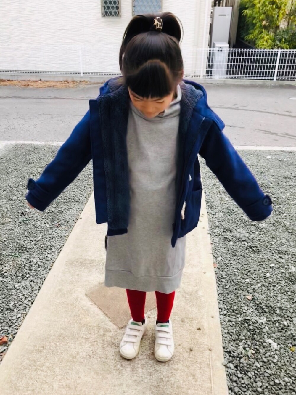 グレー系のワンピース、ホワイト系のスニーカー、ブラック系のスニーカーを着用したキッズの冬コーディネートの1枚目の写真