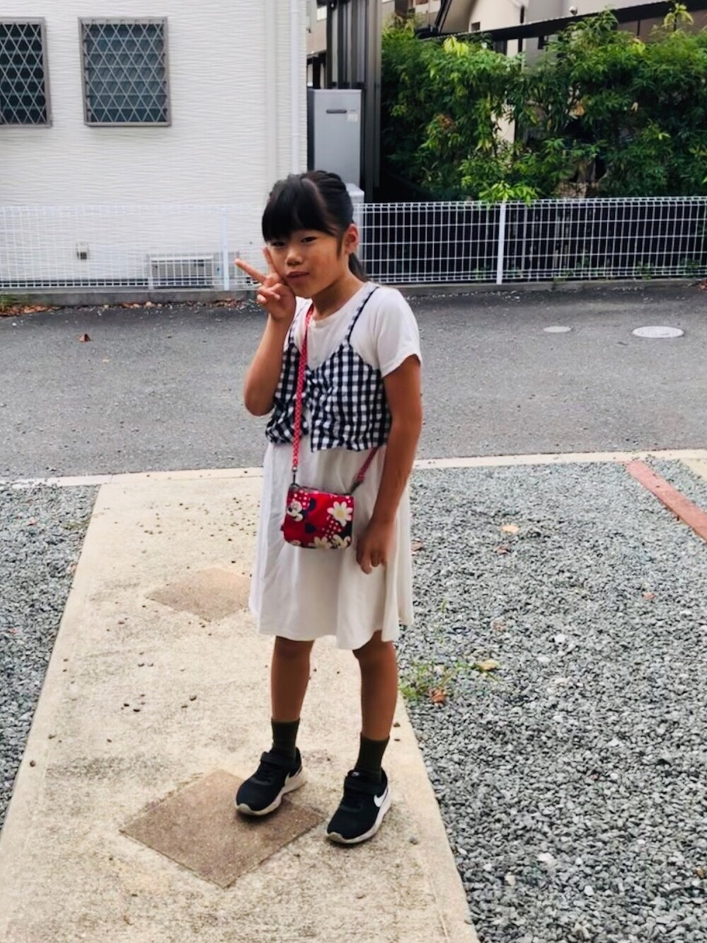 ホワイト系のワンピース、ブラック系のスニーカー、ブラック系のワンピースを着用したキッズの秋コーディネートの1枚目の写真