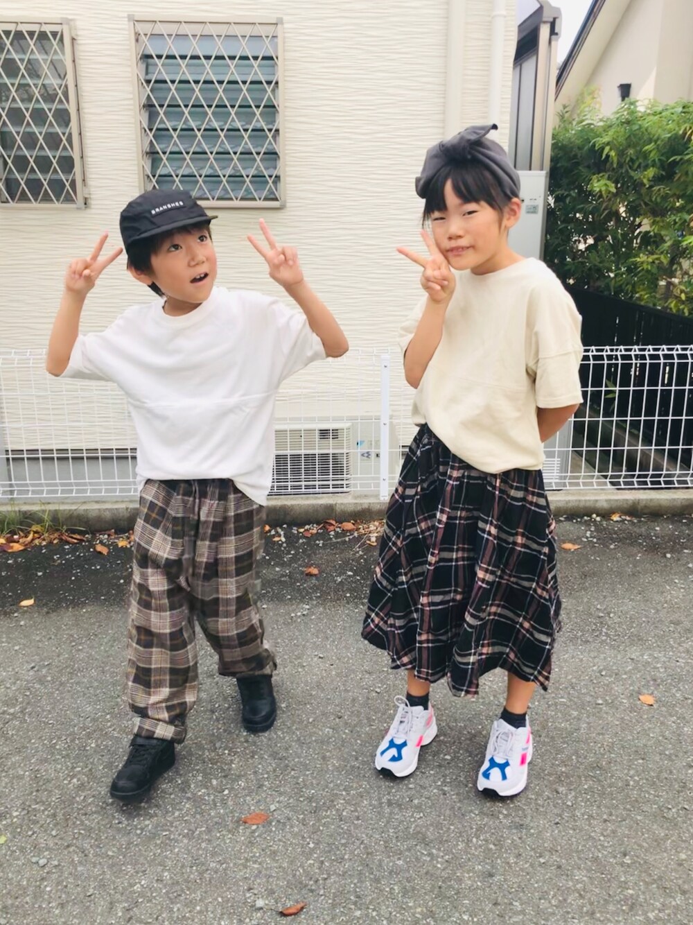 ホワイト系のTシャツ/カットソー、グレー系のその他パンツ、ブラック系のスニーカーを着用したキッズの秋コーディネートの1枚目の写真