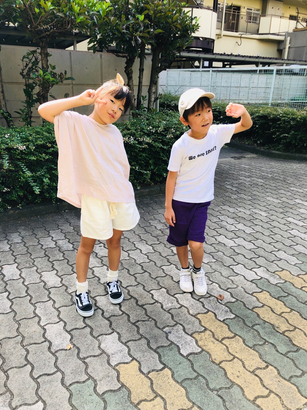 ピンク系のチュニック、ホワイト系のデニムパンツ、ブラック系のスニーカーを着用したキッズの秋コーディネートの1枚目の写真