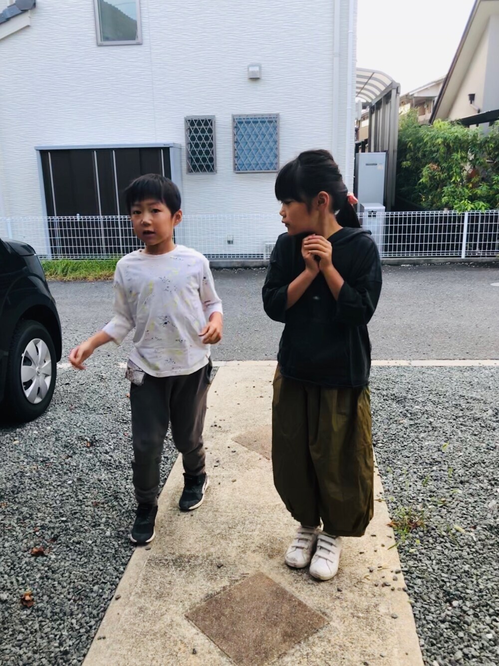 ホワイト系のTシャツ/カットソー、グレー系のスウェットパンツ、ブラック系のパーカーを着用したキッズの秋コーディネートの1枚目の写真