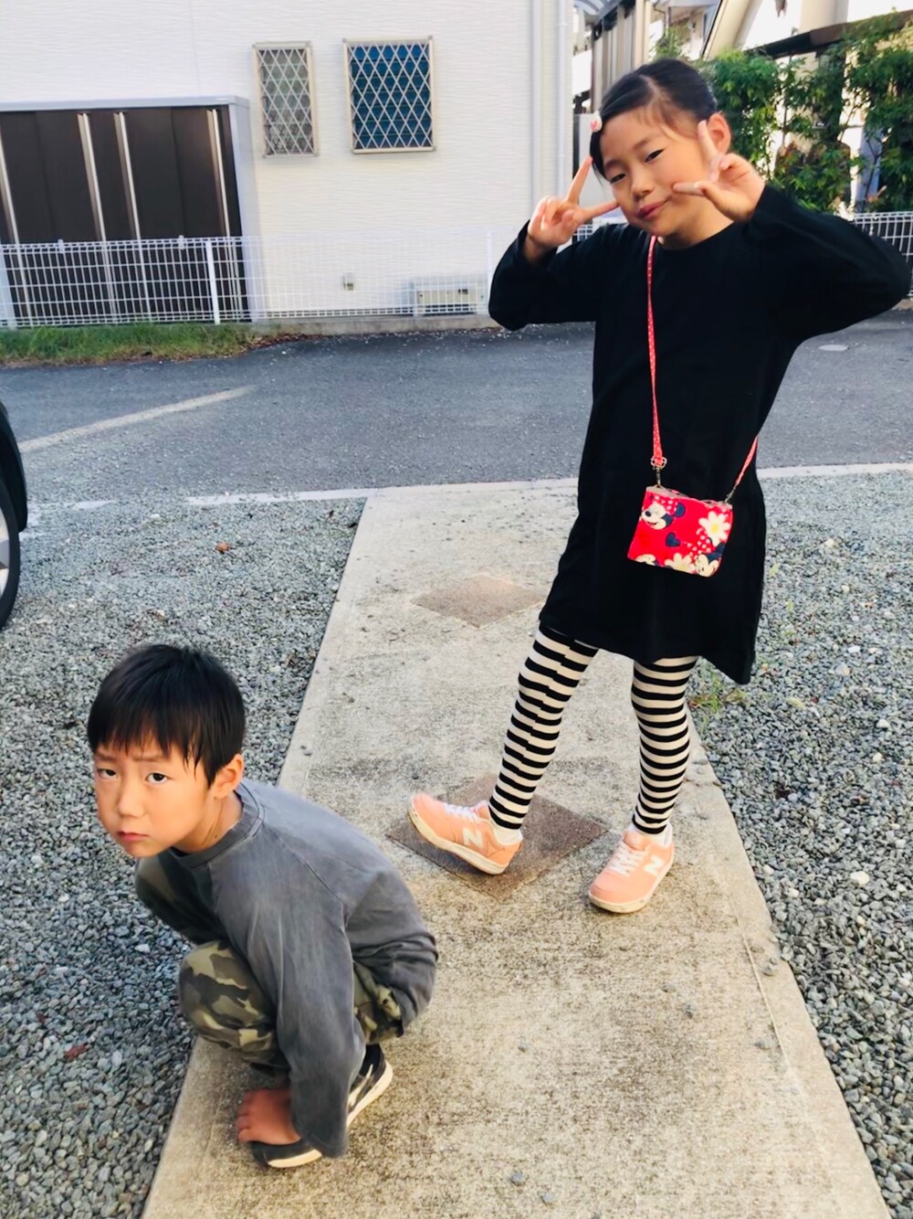 ブラック系のワンピース、ピンク系のスニーカー、グレー系のTシャツ/カットソーを着用したキッズの秋コーディネートの1枚目の写真