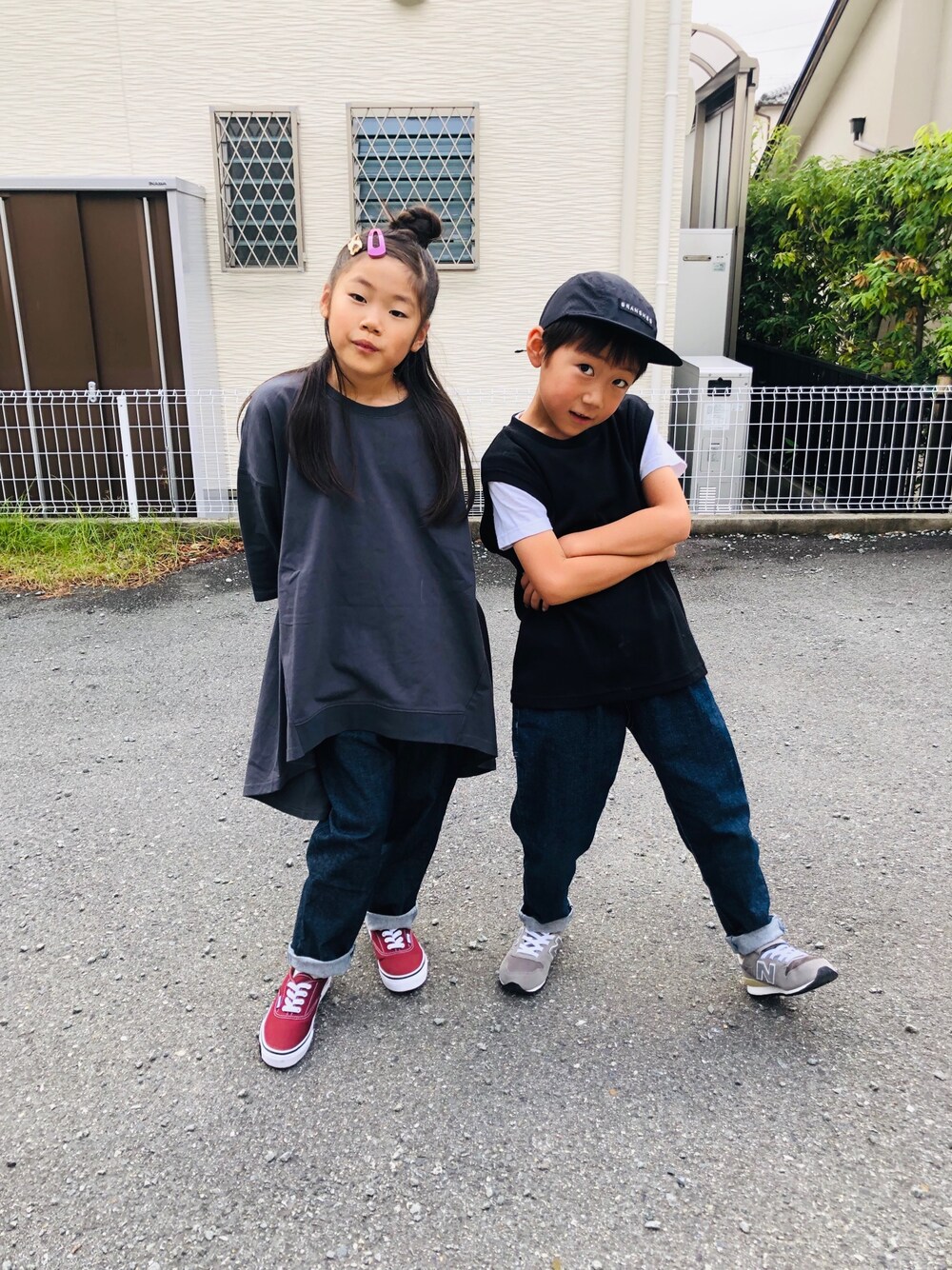 グレー系のチュニック、ブルー系のデニムパンツ、レッド系のスニーカーを着用したキッズの秋コーディネートの1枚目の写真