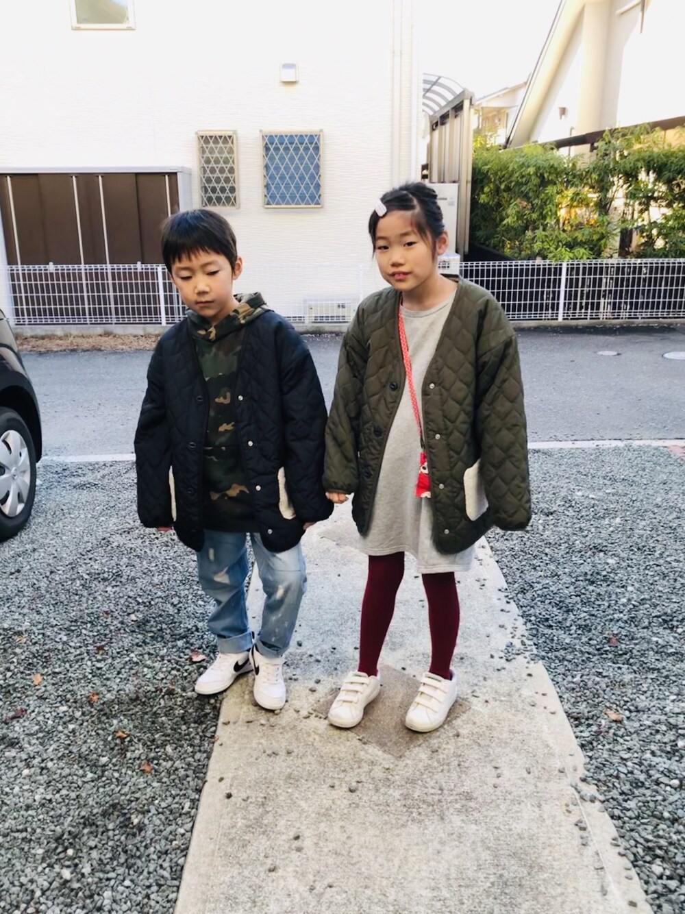 グリーン系のパーカー、ブルー系のデニムパンツ、ホワイト系のスニーカーを着用したキッズの冬コーディネートの1枚目の写真