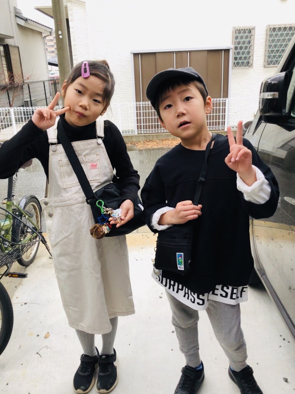 ホワイト系のジャンパースカート、ブラック系のスウェット、グレー系のその他パンツを着用したキッズの冬コーディネートの1枚目の写真