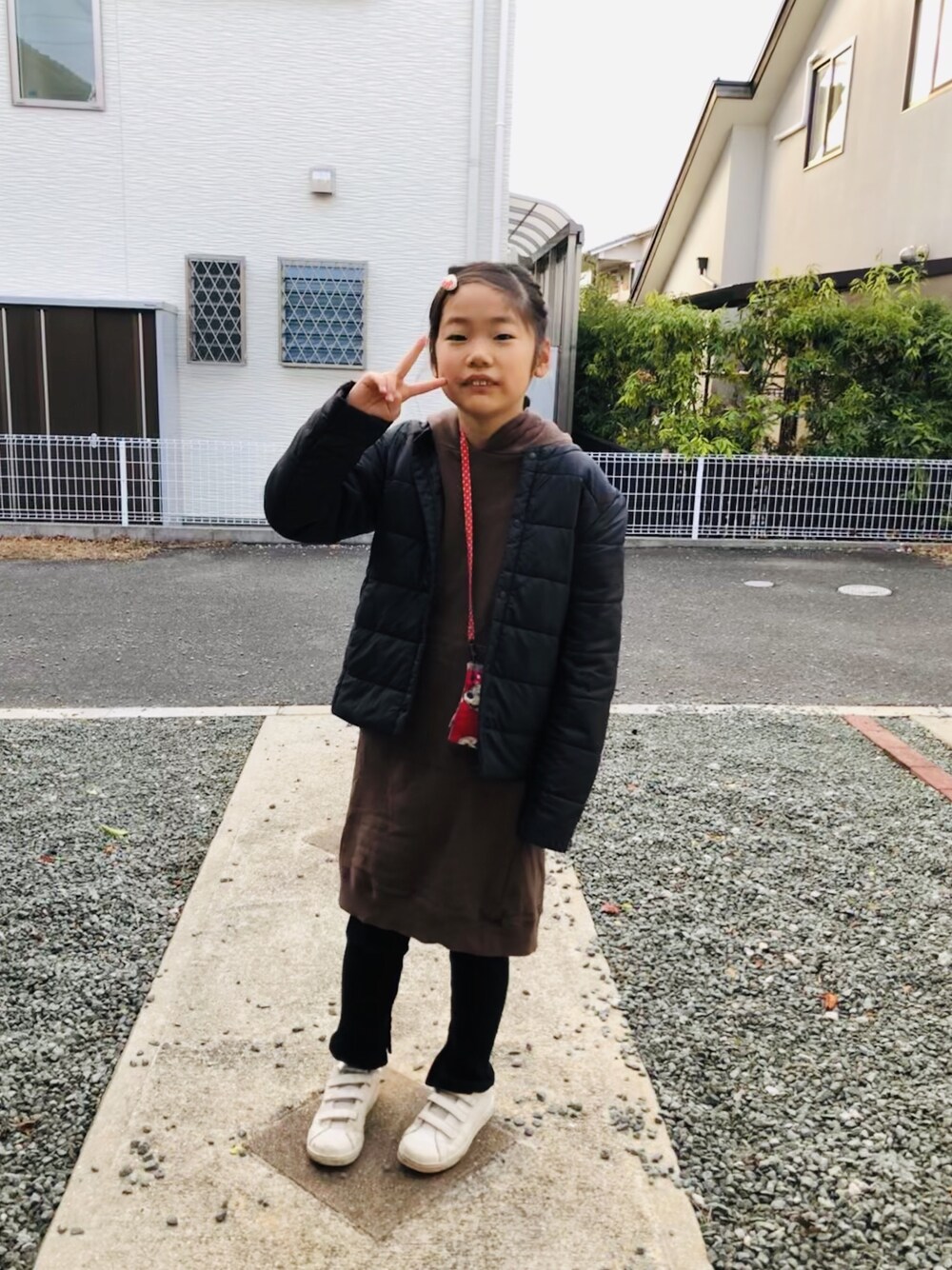 ブラウン系のワンピース、グリーン系のスニーカー、ブラック系のレギンス/スパッツを着用したキッズの冬コーディネートの1枚目の写真