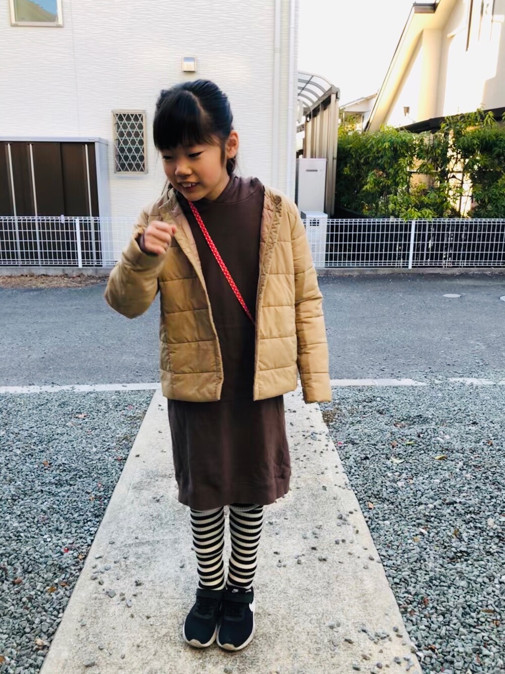 ブラウン系のワンピース、ブラック系のスニーカー、その他のレギンス/スパッツを着用したキッズの冬コーディネートの1枚目の写真