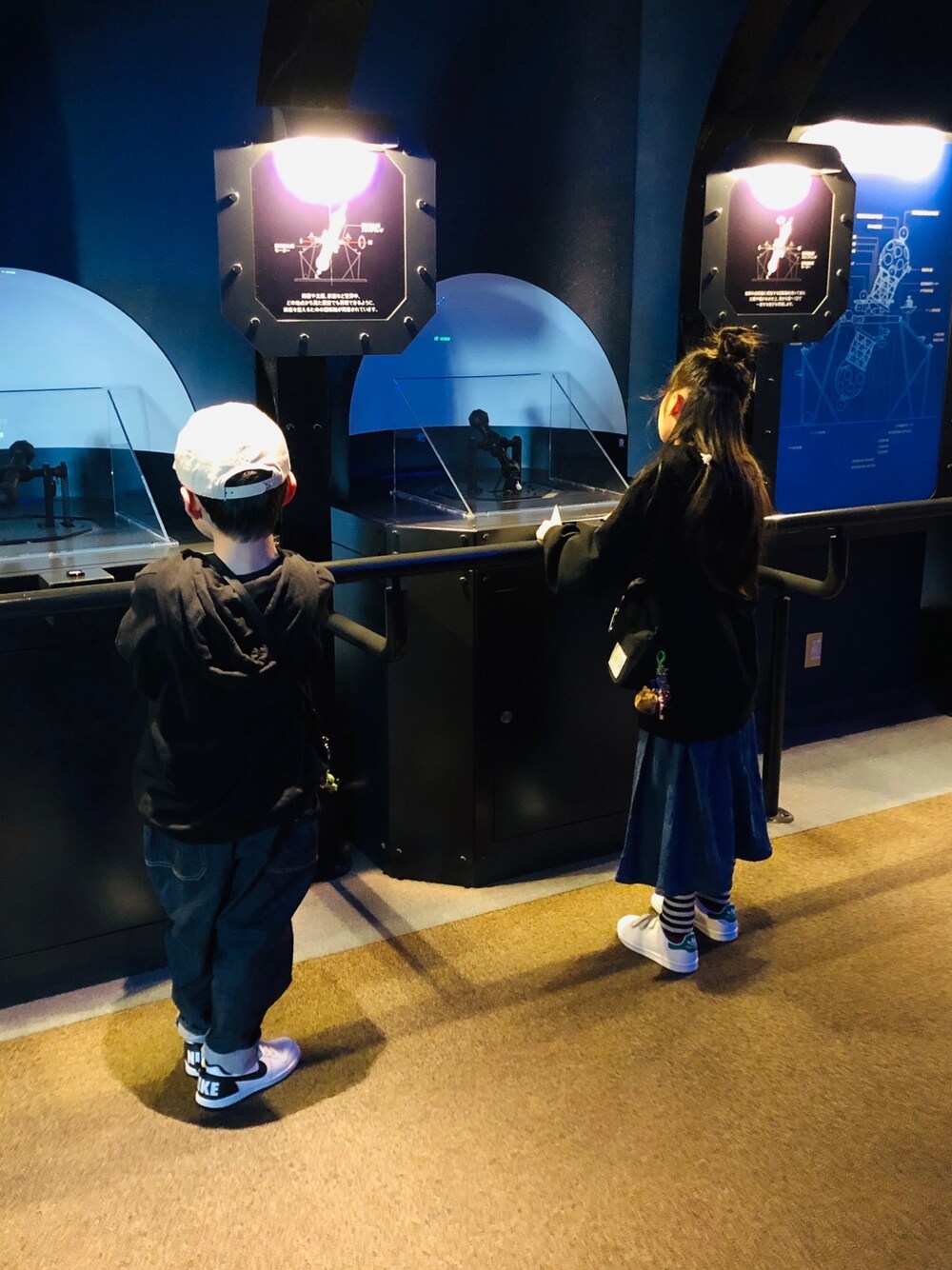 ブルー系のデニムパンツ、ホワイト系のスニーカー、ブルー系のスカートを着用したキッズの冬コーディネートの1枚目の写真