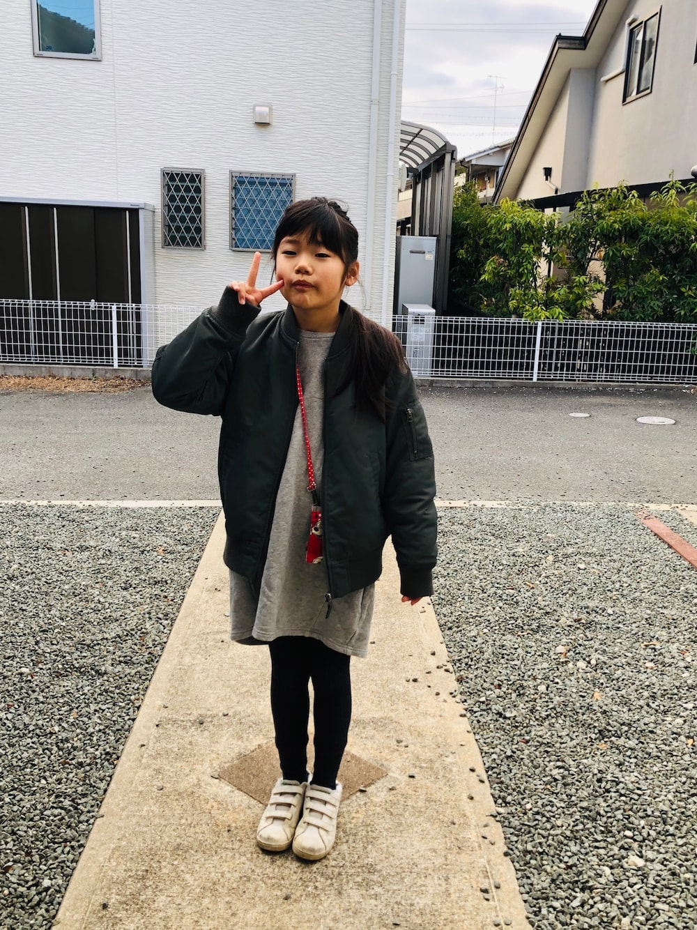 グレー系のワンピース、グリーン系のスニーカー、グレー系のワンピースを着用したキッズの冬コーディネートの1枚目の写真
