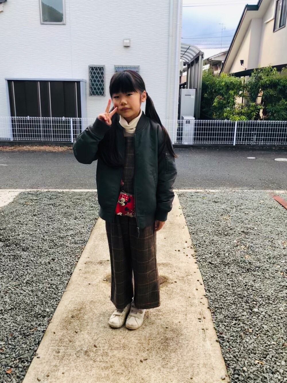 ホワイト系のTシャツ/カットソー、ブラウン系のデニムパンツ、グリーン系のスニーカーを着用したキッズの春コーディネートの1枚目の写真