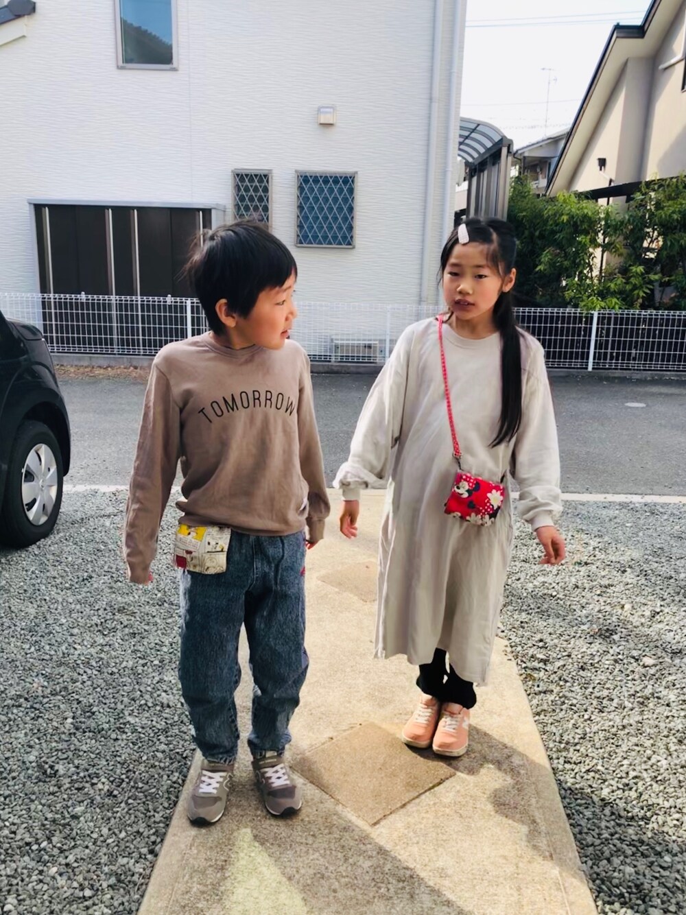 ブルー系のデニムパンツ、グレー系のスニーカー、グレー系のワンピースを着用したキッズの春コーディネートの1枚目の写真