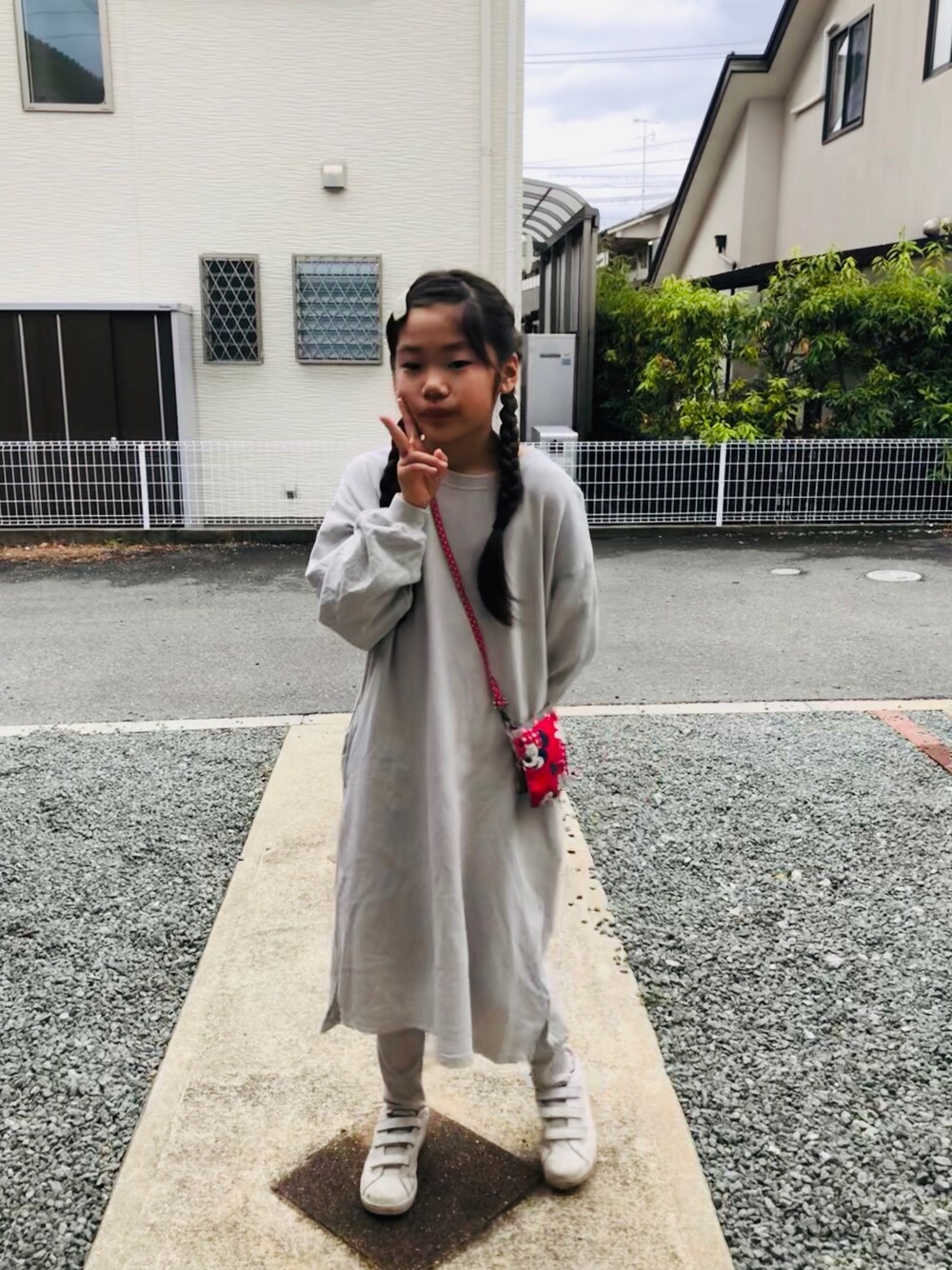 グレー系のワンピース、ベージュ系のレギンス/スパッツを着用したキッズの春コーディネートの1枚目の写真