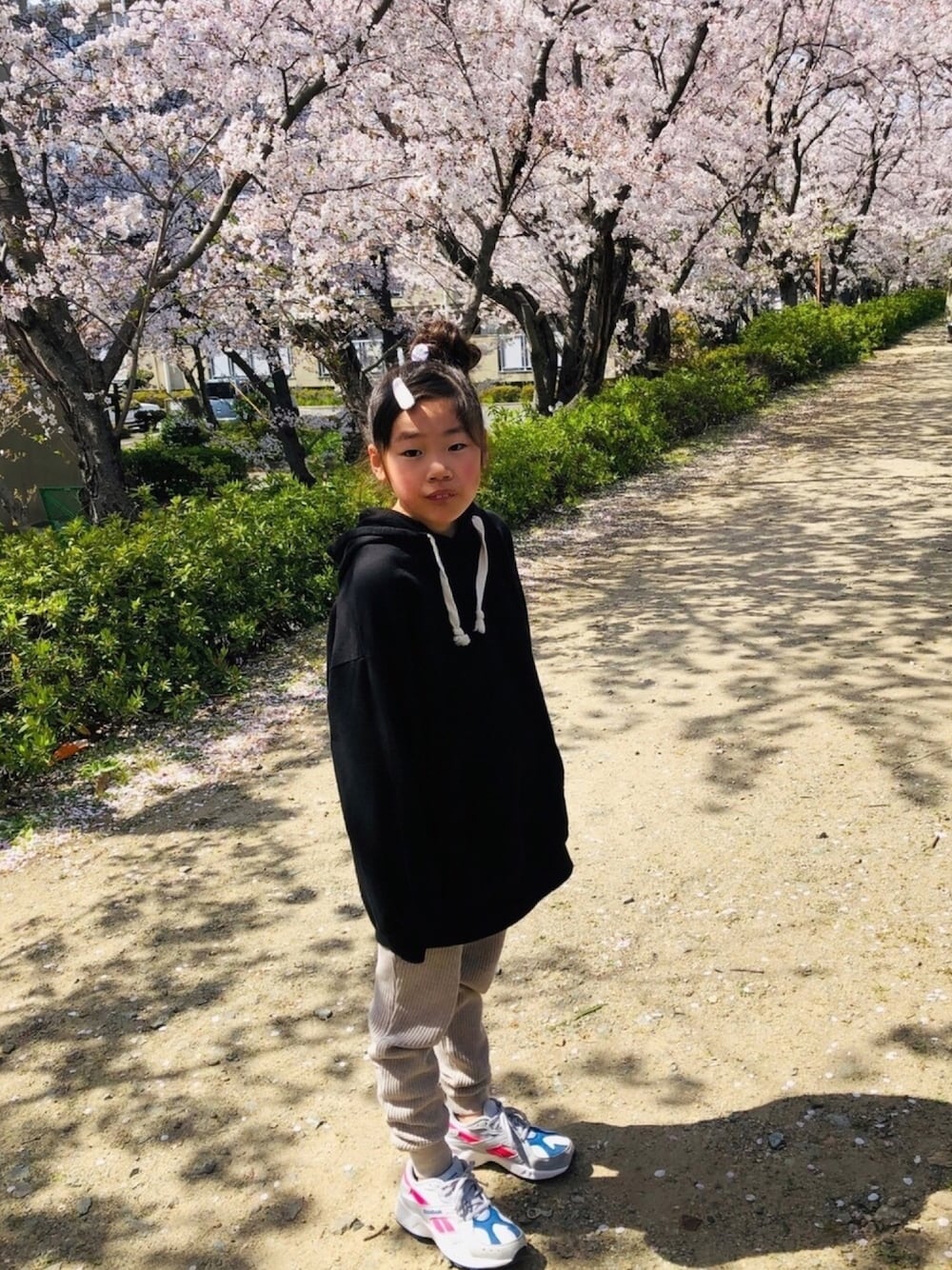 グレー系のスニーカー、グリーン系のワンピース、ブルー系のシャツ/ブラウスを着用したキッズの春コーディネートの1枚目の写真