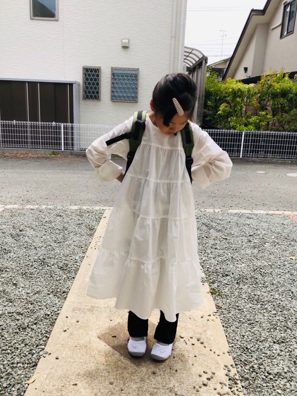 ホワイト系のワンピース、ブラック系のその他パンツ、ホワイト系のスニーカーを着用したキッズの春コーディネートの1枚目の写真