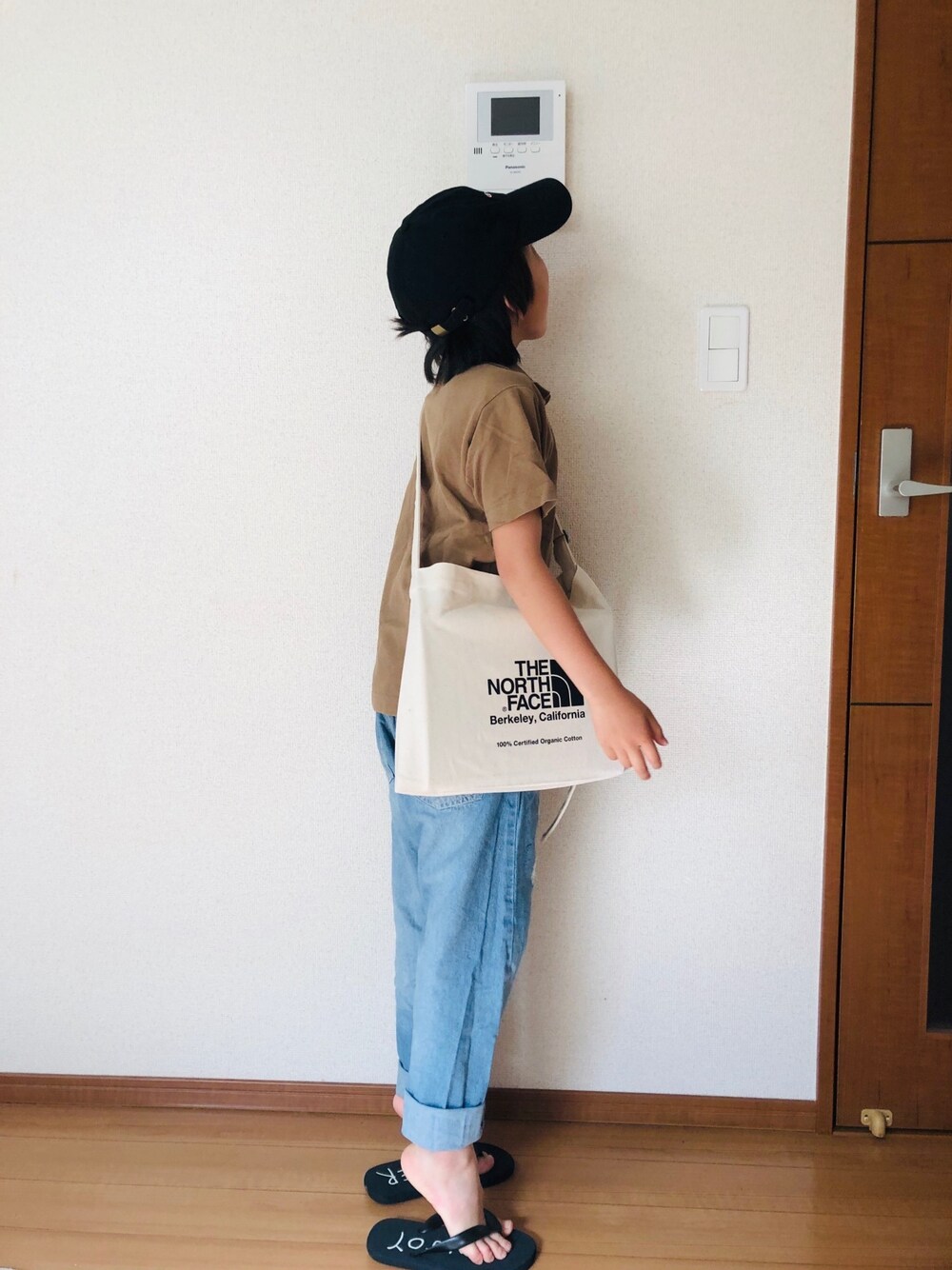 ベージュ系のポロシャツ、ブルー系のデニムパンツ、ブラック系のショルダーバッグを着用したキッズの夏コーディネートの1枚目の写真