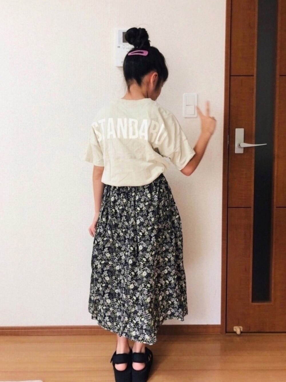 ブラック系のサンダル、ブラック系のスカート、ベージュ系のTシャツ/カットソーを着用したキッズの秋コーディネートの1枚目の写真