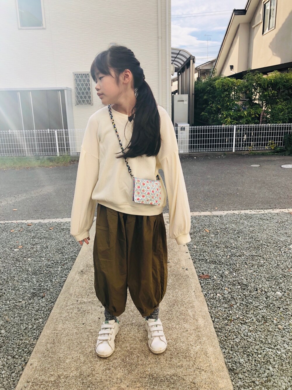 ホワイト系のTシャツ/カットソー、グリーン系のその他パンツ、ホワイト系のスニーカーを着用したキッズの秋コーディネートの1枚目の写真