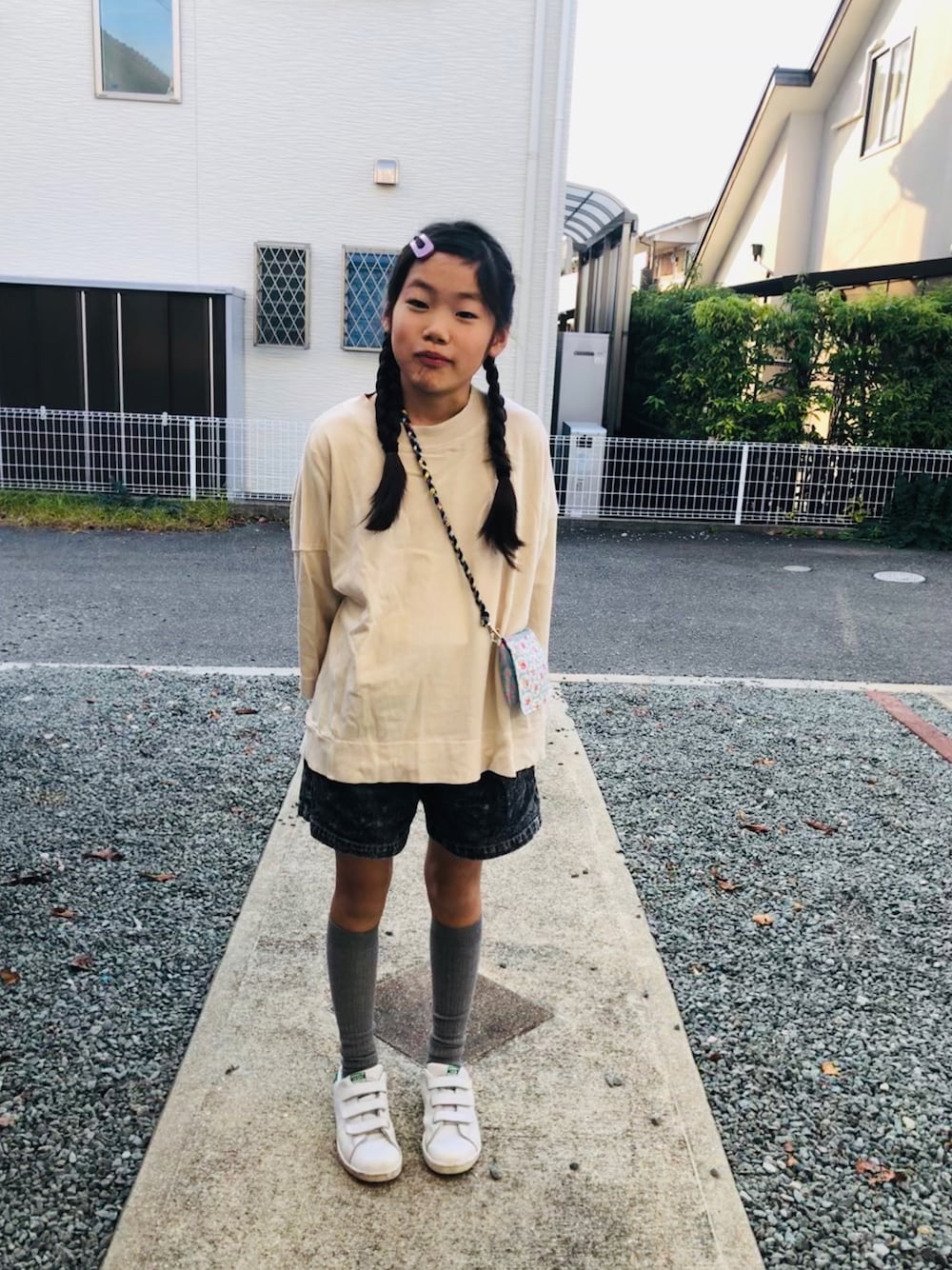 ベージュ系のTシャツ/カットソー、ブラック系のデニムパンツ、ホワイト系のスニーカーを着用したキッズの秋コーディネートの1枚目の写真