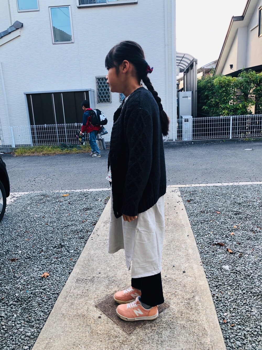 グレー系のワンピース、ブラック系のその他パンツ、ピンク系のスニーカーを着用したキッズの秋コーディネートの1枚目の写真