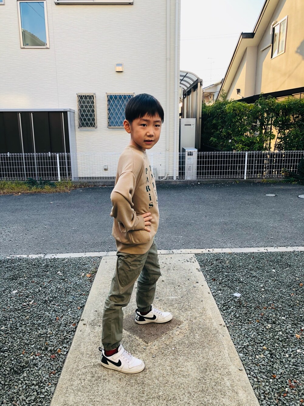 ベージュ系のスウェット、グリーン系のその他パンツ、ホワイト系のスニーカーを着用したキッズの秋コーディネートの1枚目の写真