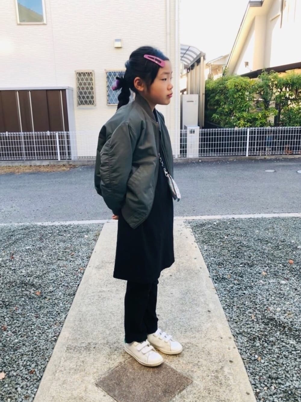 ブラック系のワンピース、ブラック系のその他パンツ、ホワイト系のスニーカーを着用したキッズの冬コーディネートの1枚目の写真