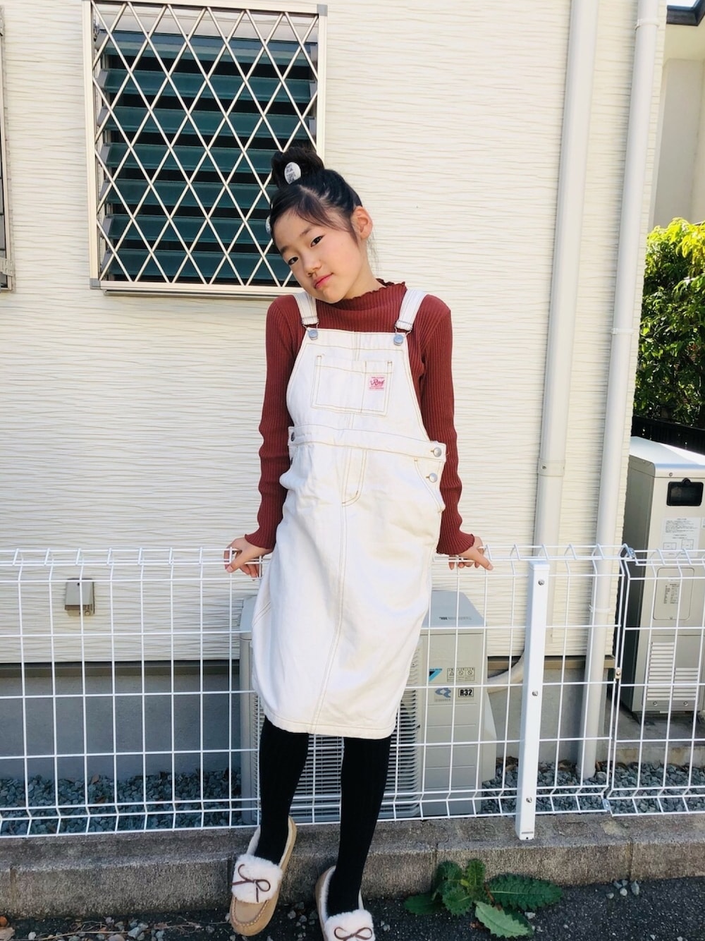 ホワイト系のジャンパースカート、ブラック系のタイツ/ストッキング、その他のヘアゴムを着用したキッズの冬コーディネートの1枚目の写真