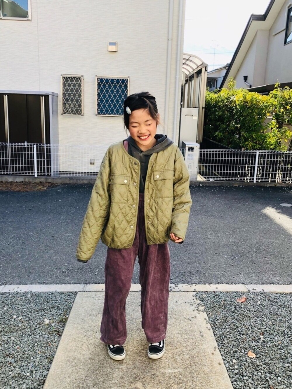 グレー系のパーカー、ピンク系のサロペット/オーバーオール、グリーン系のブルゾンを着用したキッズの冬コーディネートの1枚目の写真