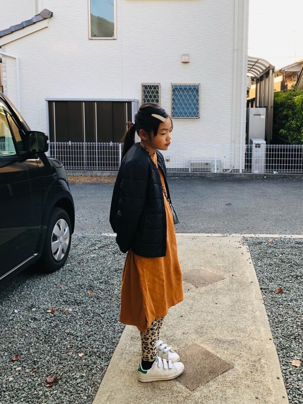 ブラウン系のワンピース、ホワイト系のスニーカー、ブラック系のドレスシューズを着用したキッズの冬コーディネートの1枚目の写真