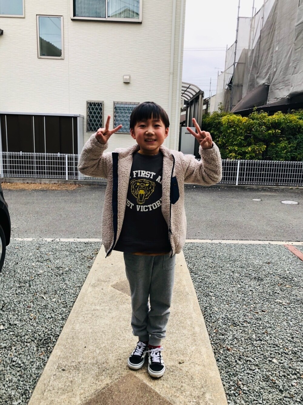 ブラック系のスニーカー、ホワイト系のブルゾン、グレー系のスカートを着用したキッズの冬コーディネートの1枚目の写真