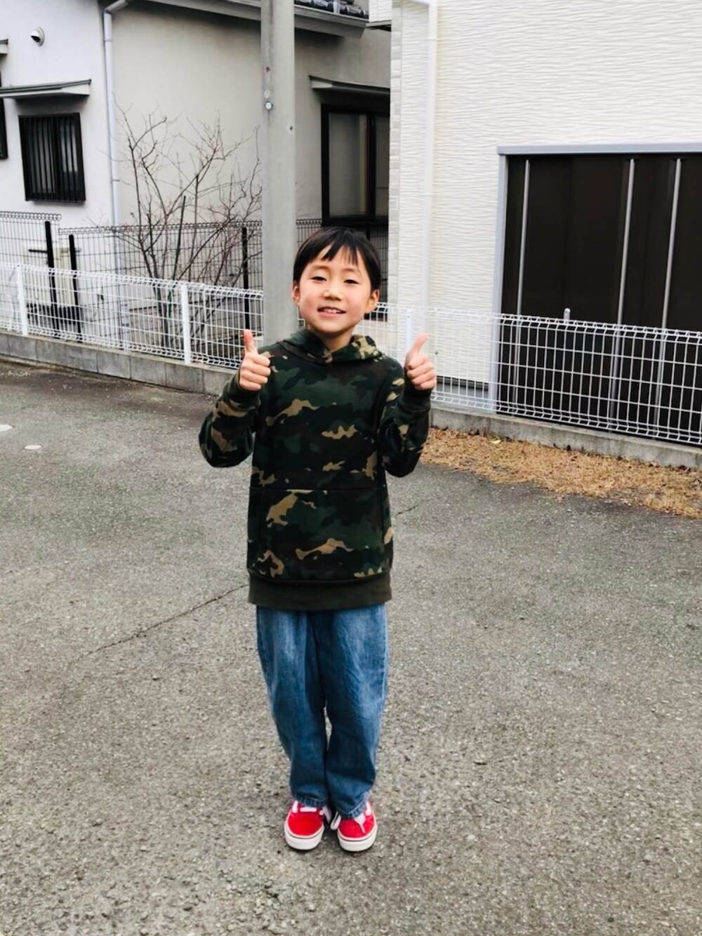 グリーン系のパーカー、ブルー系のその他パンツ、レッド系のスニーカーを着用したキッズの冬コーディネートの1枚目の写真