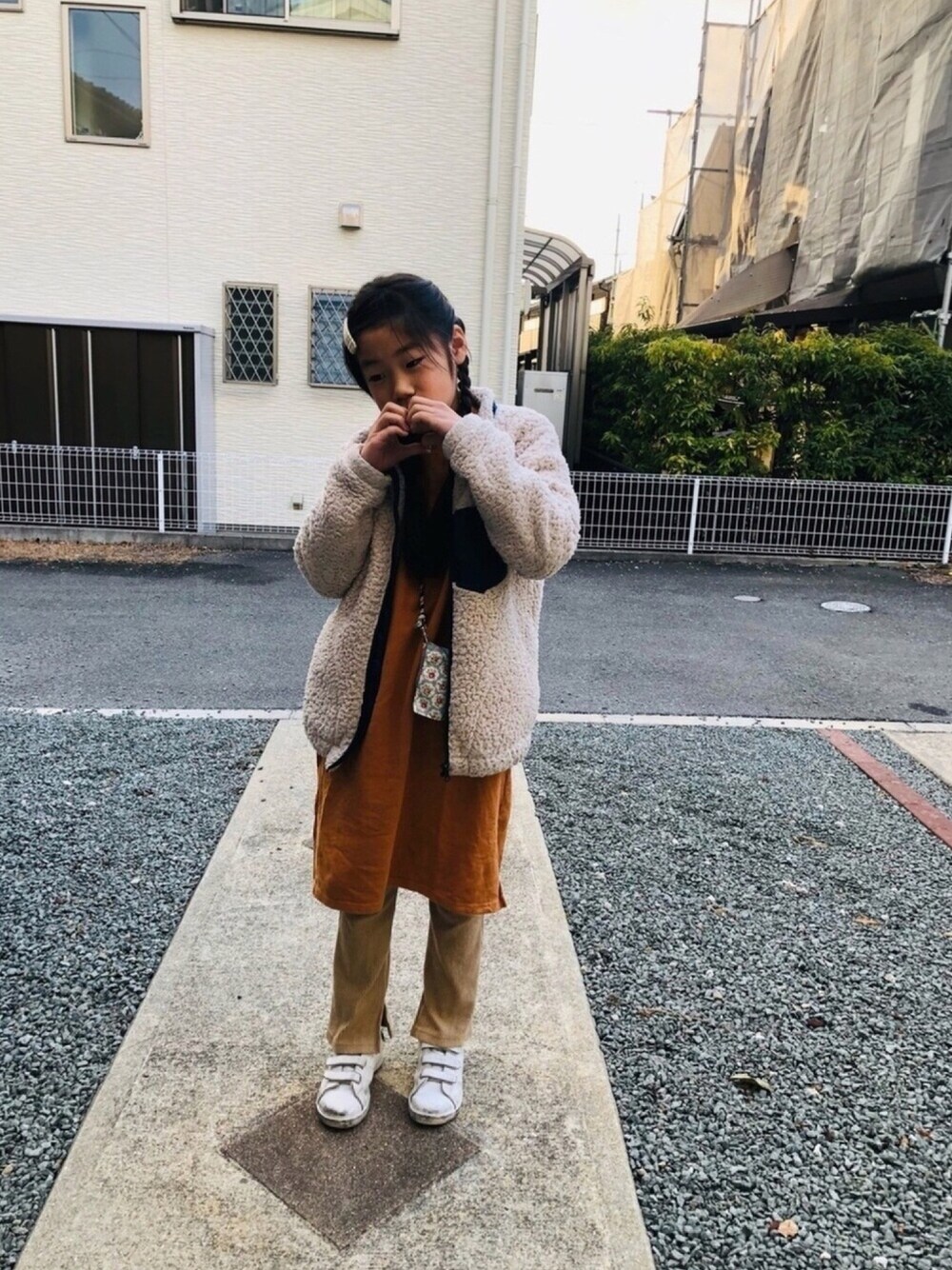 ブラウン系のワンピース、ベージュ系のその他パンツ、ホワイト系のスニーカーを着用したキッズの冬コーディネートの1枚目の写真