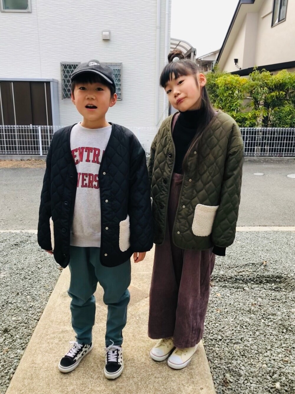 ブラック系のブルゾン、グリーン系のブルゾン、ホワイト系のスニーカーを着用したキッズの春コーディネートの1枚目の写真