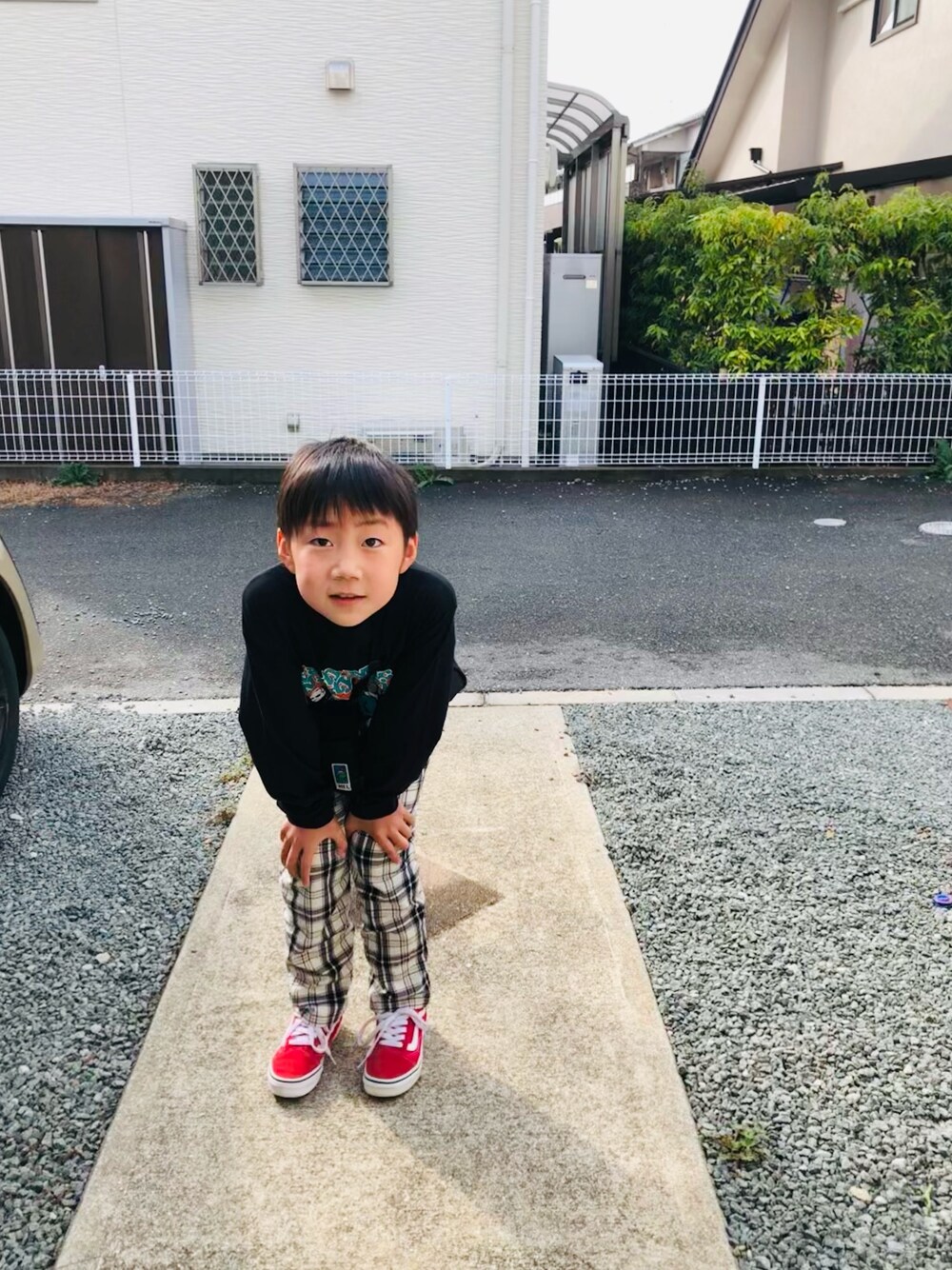 ブラック系のTシャツ/カットソー、ホワイト系のその他パンツ、レッド系のスニーカーを着用したキッズの春コーディネートの1枚目の写真