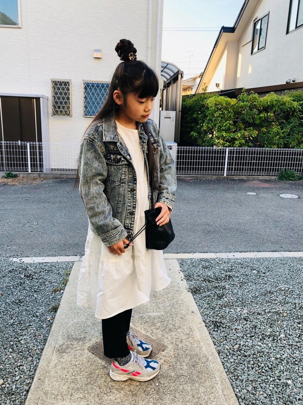 ホワイト系のワンピース、ブラック系のその他パンツ、グレー系のスニーカーを着用したキッズの春コーディネートの1枚目の写真